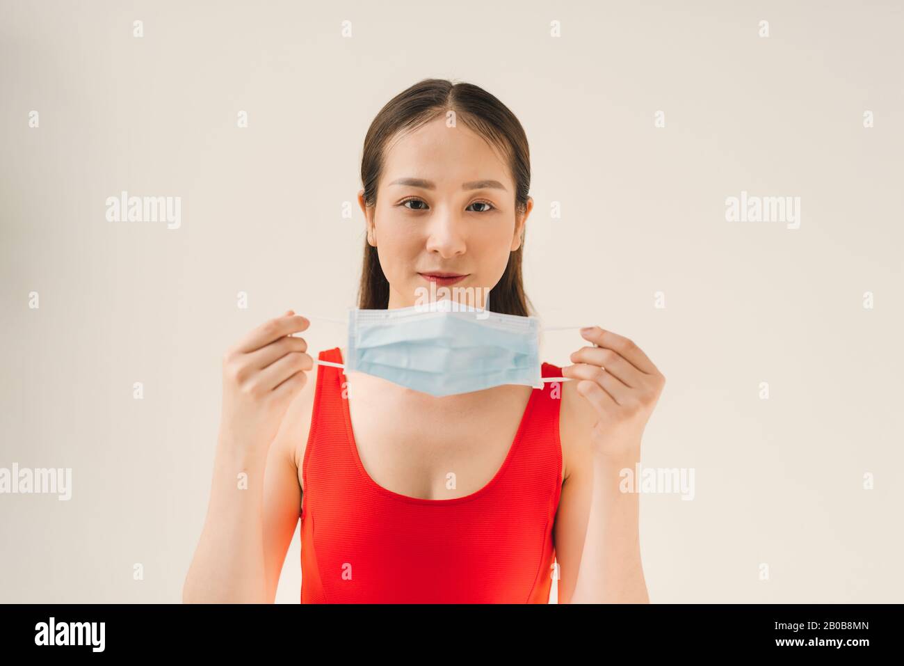 Junge Asiatin, die eine Maske trägt, um Keime, giftige Dämpfe und Staub zu verhindern. Prävention von bakteriellen Infektionen in der Luft in einem weißen Hintergrund Stockfoto