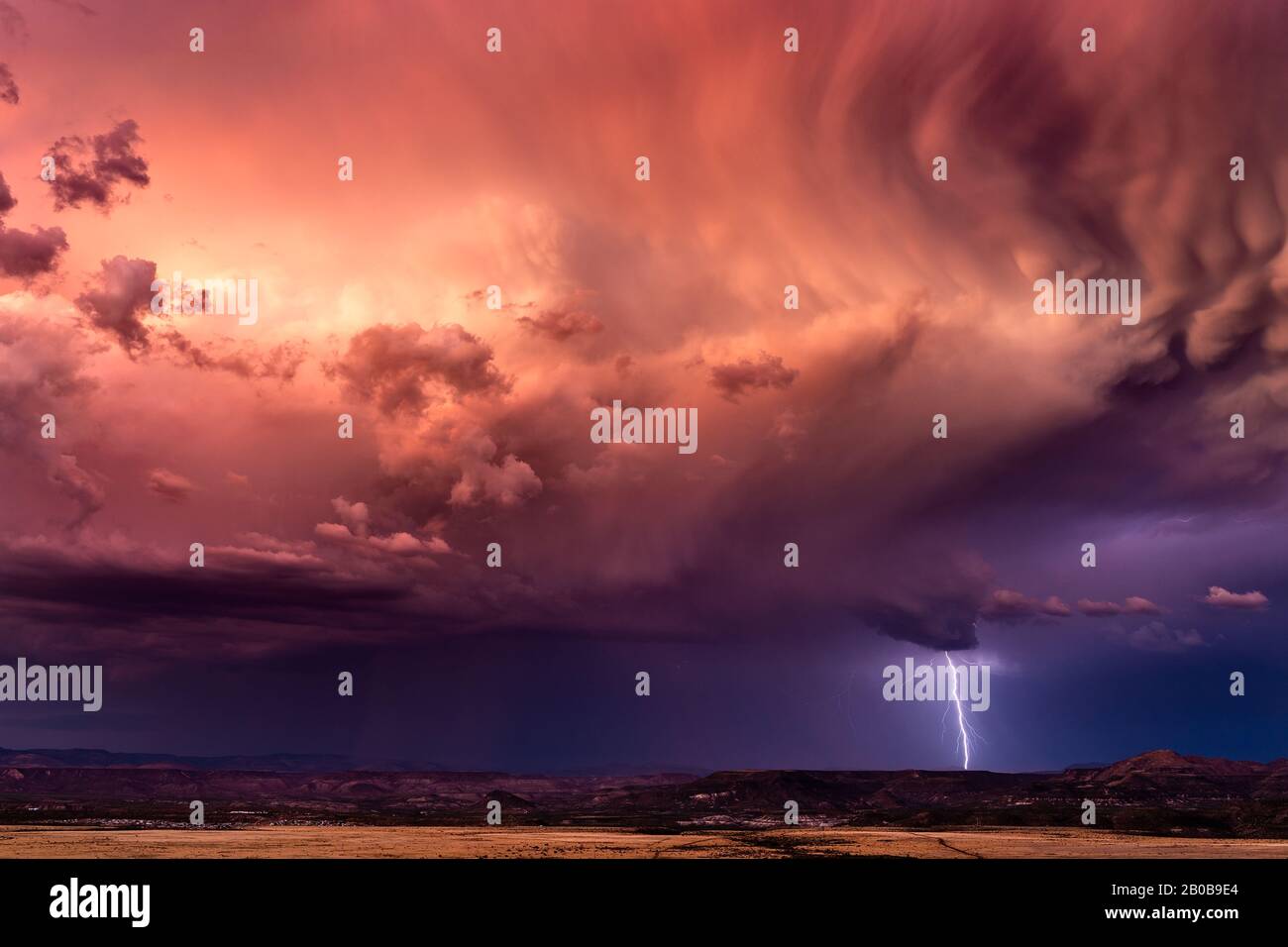 Stürmischer Himmel mit dramatischen Wolken und Blitzen bei Sonnenuntergang Stockfoto