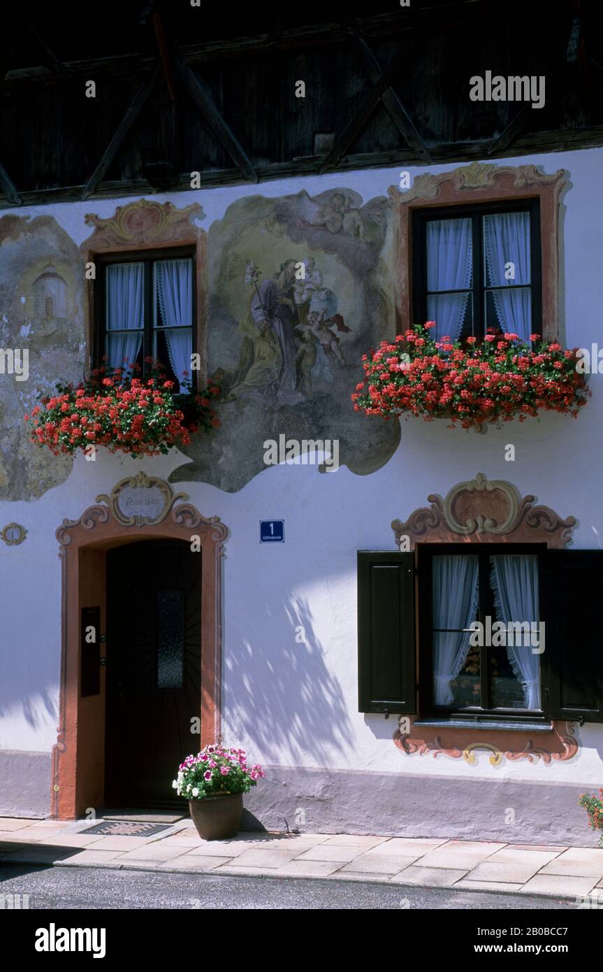 DEUTSCHLAND, BAYERN, OBERAMMERGAU, BEMALTES HAUS, TÜR UND FENSTER, BLUMENKÄSTEN MIT GERANIEN Stockfoto