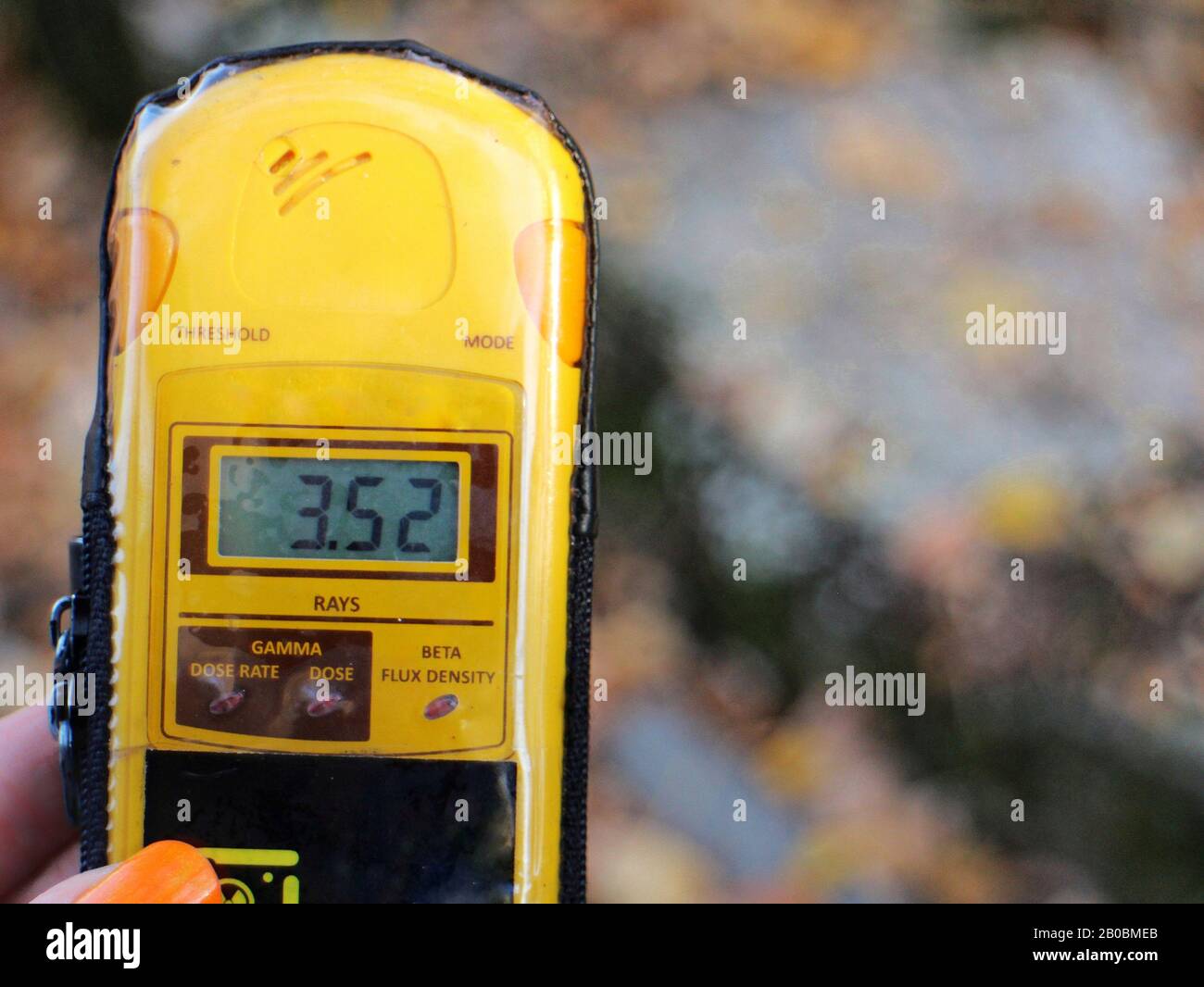 Ein Dosimeter wird gehalten, das 3,52 Millisieverts in der Nähe eines "Hot Spot" in der Ausschlusszone von Tschernobyl, Ukraine, zeigt, etwas weniger als das eines zahnärztlichen Röntgenstrahls. Stockfoto