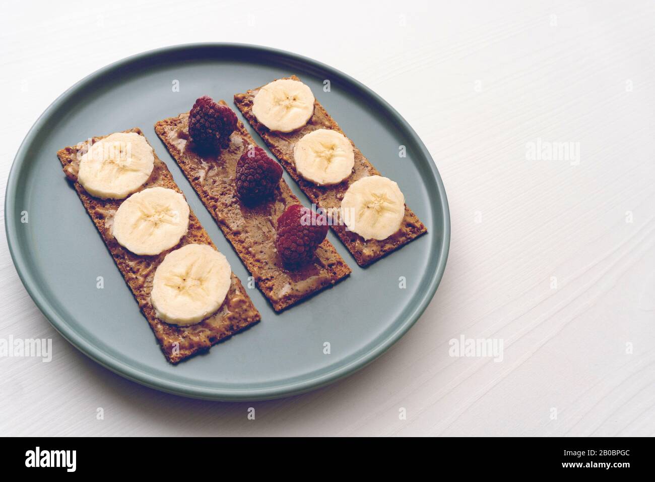 Erdnussbutter Toast mit Banane und Himbeere Stockfoto