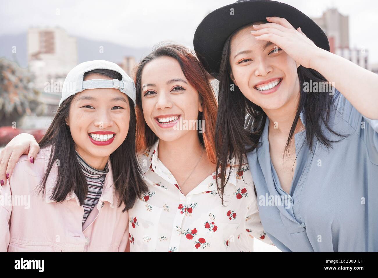 Asiatische Frauen haben Spaß im Freien - Fröhliche trendige Mädchen lachen zusammen - Millennial-Generation, Bonding, Freundschaft und Sammelkonzept - Foc Stockfoto