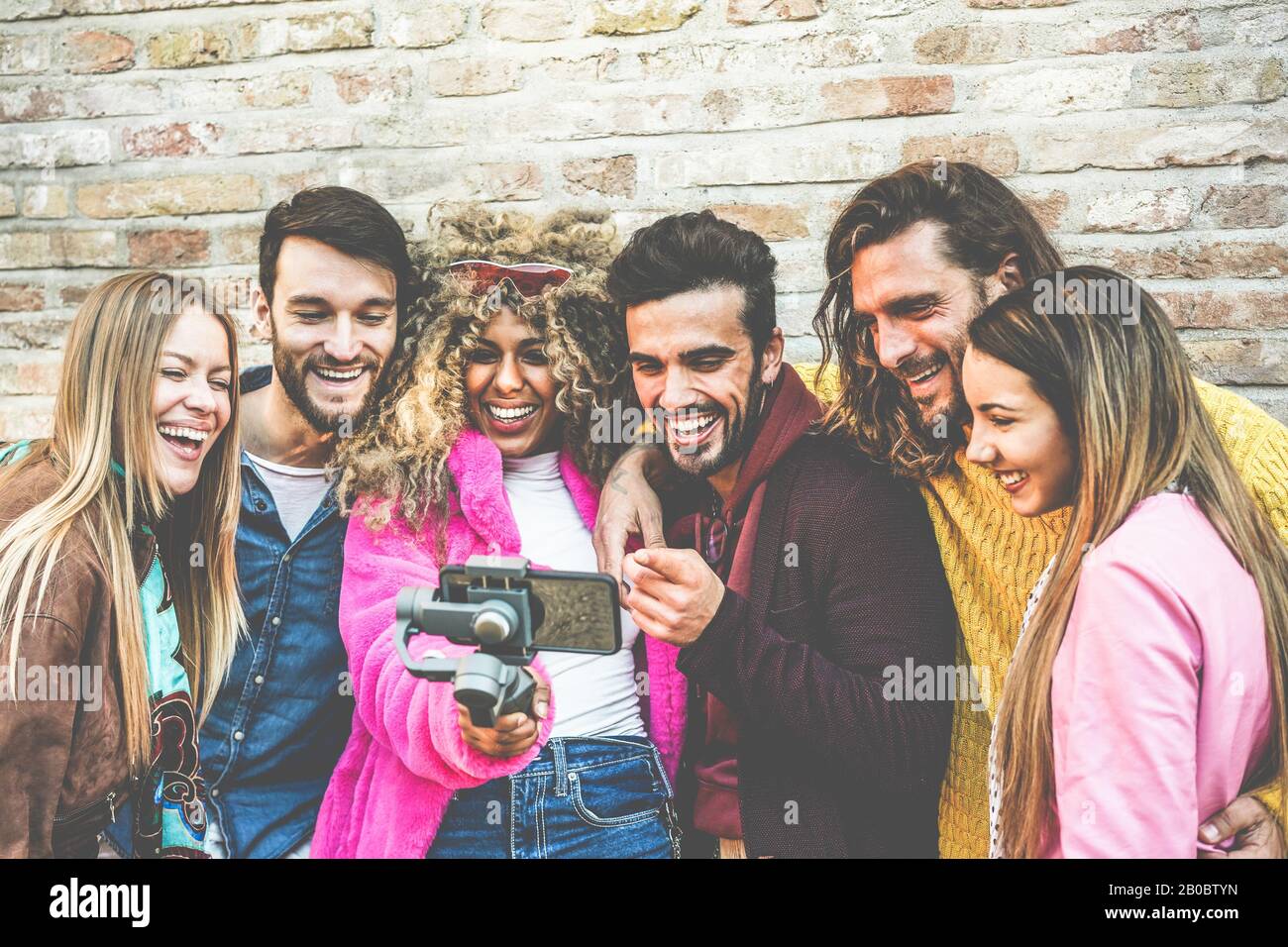 Fröhlicher Vlogger, der mit Freunden Videofeeds über Smartphone im Freien macht - Junge Leute haben Spaß mit neuen Technologietrends - Jugend-Lifestyle und Socia Stockfoto