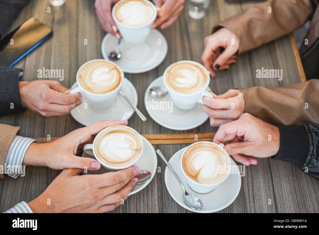 Die Leute sehen den Blick auf den Cappuccino in der Vintage Cafeteria Bar - Junge Freunde, die während der Wintersaison ein Frühstück machen - Kleben und Kaffee warm sein Stockfoto