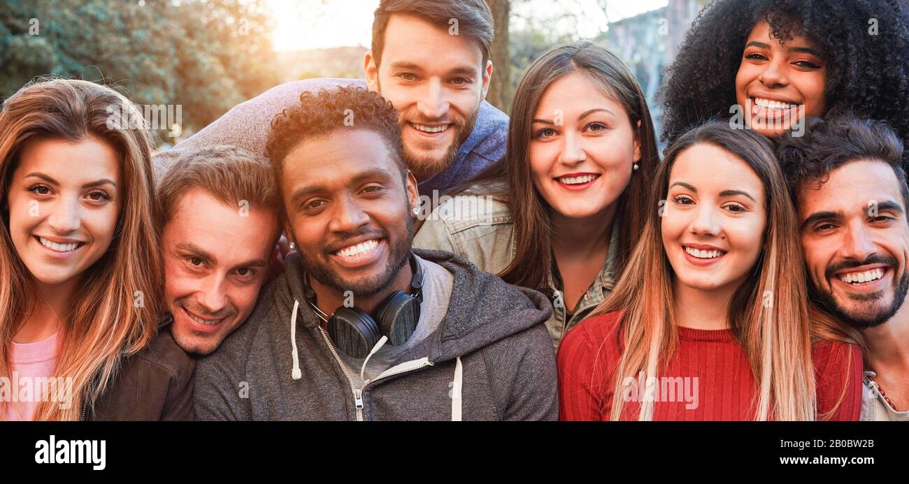 Fröhliche tausendjährige Freunde aus verschiedenen Kulturen und Rassen, die Spaß haben, sich vor der Smartphone-Kamera zu posieren - Jugend- und Freundschaftskonzept - Junges Multir Stockfoto