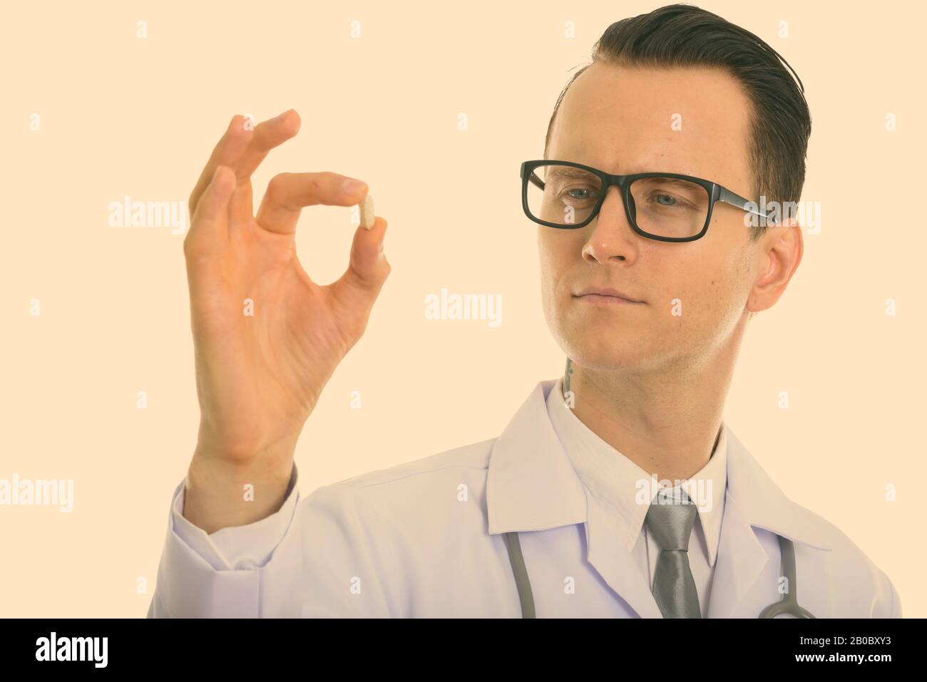 Studio shot Junger stattlicher Mann Arzt eng an Vitamin Tablette suchen Stockfoto