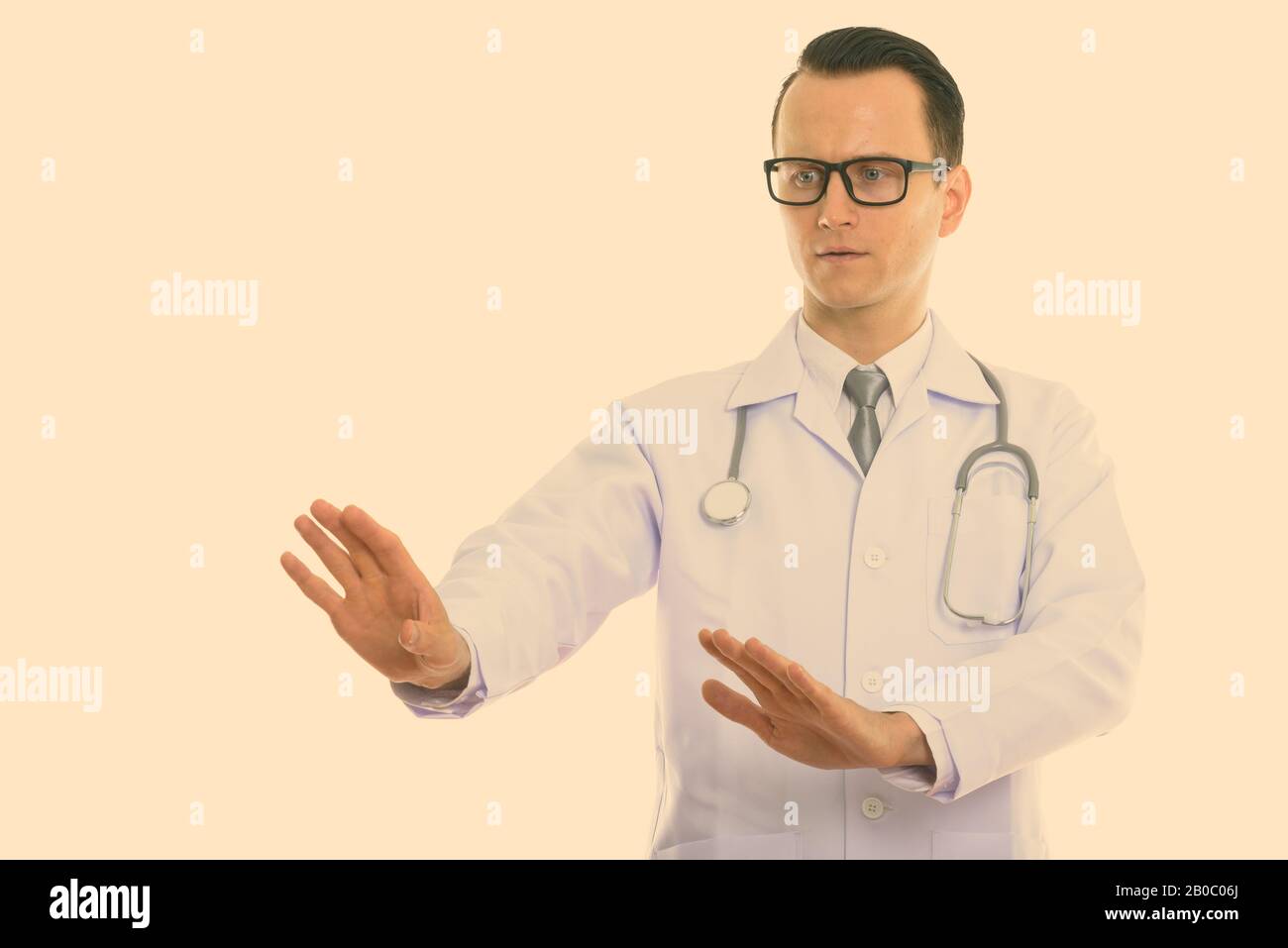 Studio shot Junger stattlicher Mann, in dem der Arzt Ihnen sagte anzuhalten und nach unten schauen. Stockfoto