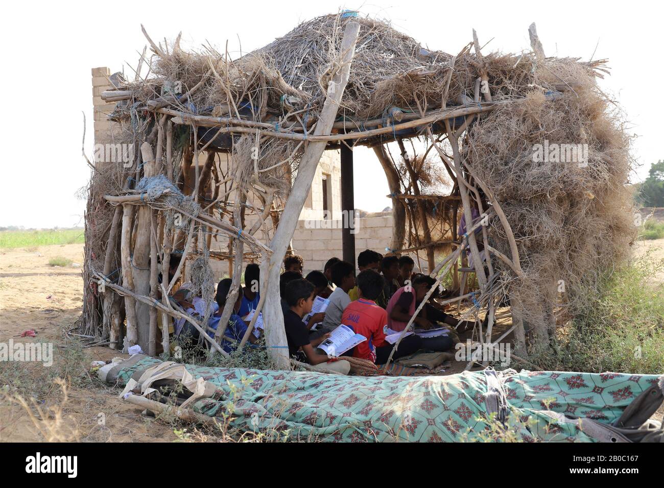 Hajjah, Jemen. Feb. 2020. Studenten studieren in einer Hütte, die als Klassenraum an einer Schule im Haradh-Distrikt in der Provinz Hajjah, Jemen, 19. Februar 2020 genutzt wird. Ende 2019 hat der Krieg im Jemen mehr als zwei Millionen Kinder aus der Schule gedrängt und 3,7 Millionen andere wegen der Nichtzahlung von Lehrergehältern in ein hohes Risiko gesteckt, so der Kinderhilfswerk der Vereinten Nationen (UNICEF). Gutschrift: Mohammed Mohammed/Xinhua/Alamy Live News Stockfoto