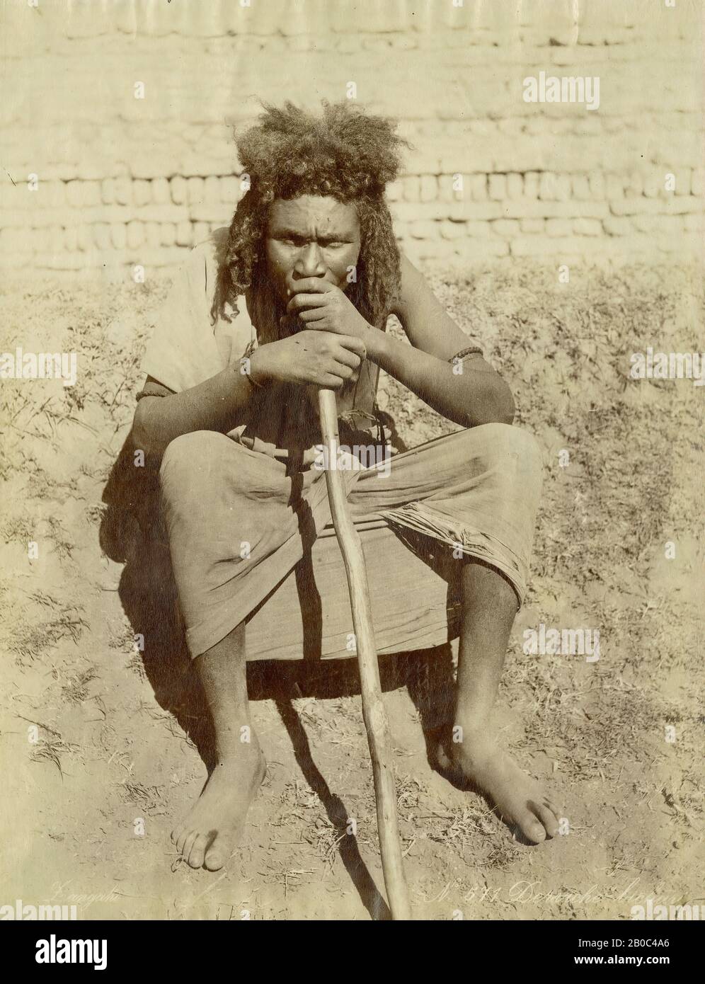 Zangaki, Mann Auf Dem Boden Sitzend mit Stick, n.d., Vintage-Albumindruck, 10 15/16 Zoll x 8 7/16 Zoll (27,78 x 21,43 cm Stockfoto