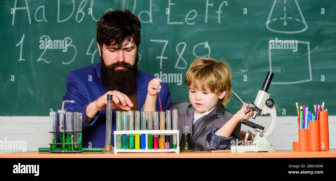 Zurück zur Schule. Frühe Entwicklung von Kindern. Experimente im Chemielabor, Vater und Sohn in der Schule, Lehrer mit kleinem Jungen. Schulische Ausbildung. Wissenschaftliche Experimente im Klassenzimmer. Stockfoto