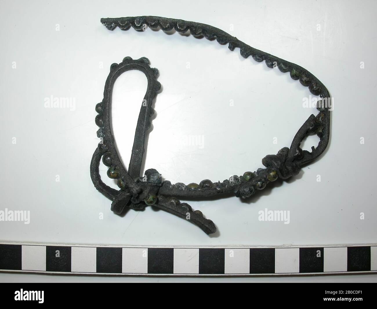 Fragment Ledergürtel mit Armaturen. Mehrere Bandabschnitte, die mit 2 Knoten zusammengebunden sind. Das ganze besteht aus 3 Fragmenten. Auf den Bruchstücken befinden sich etwa 64 dekorative Bleinägel (Durchmesser: 0,5 cm, Dicke: 0,2 - 0,4 cm) mit einer Kappe aus Kupferlegierung. Einige Stehbolzen mit Kappen fehlen komplett und es sind 4 Ziernägel ohne Kappe sichtbar. Die Farbe des Schlagbattens ist wegen der Korrosion des Bleis dunkelgrau bis schwarz. Zwischen den Kappen und den Fittings ist kein Raum so breit wie das Leder. Dicke des Bandes mit Batter: 0,6 cm. Nageldurchmesser: 0,05 - 0,15 cm Stockfoto