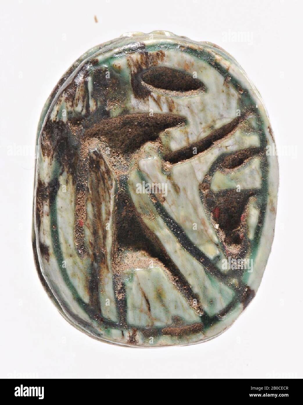 Scarab, Re, stehend, Uraeus, Die Dichtung hat die Form eines sehr grob stilisierten Skarabäus. Dreieckskopf mit ausgestelltem und gekerbtem Clypeus, Pronotum und Elytra sind durch gekerbte Linien getrennt. Der Käfer ruht auf einem ovalen Sockel, der von einer doppelten Rille umsetzt ist und auch als Dichtung dient. In der ovalen Dichtfläche wird eine rechts stehende und gewöhne Falknergottheit in einer ovalen Umrahmnut dargestellt. Sein linker Arm ist angehoben, sein rechter Arm hängt seinen Körper hinunter. Über ihm ist eine ovale, vermutlich eine Sonnenscheibe und für ihn ein rechtwinkliger Uraeusslang gekerbt. Das Objekt ist Stockfoto