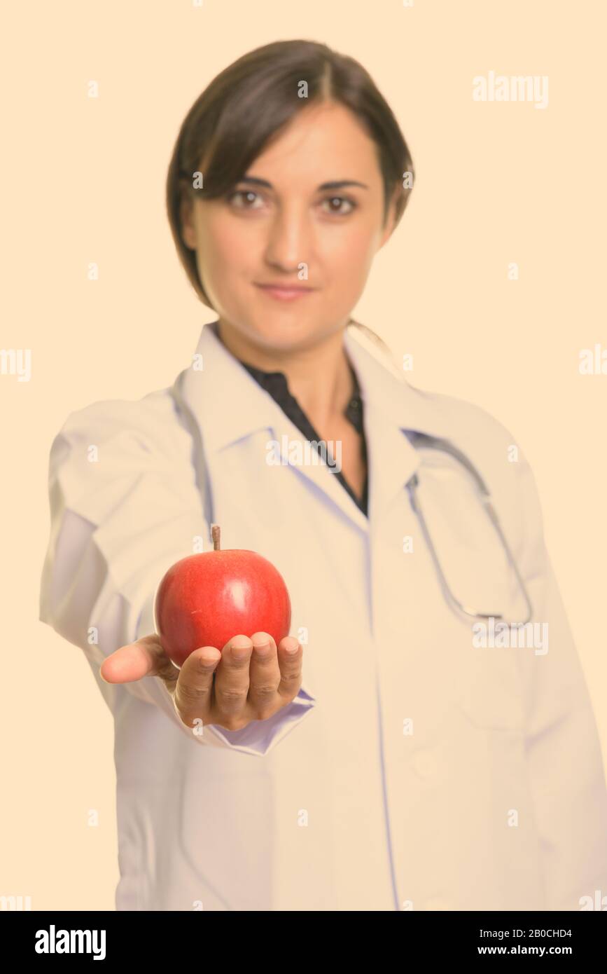 Nahaufnahme eines schönen Frauenarztes, der roten apfel mit dem Schwerpunkt apfel gibt Stockfoto