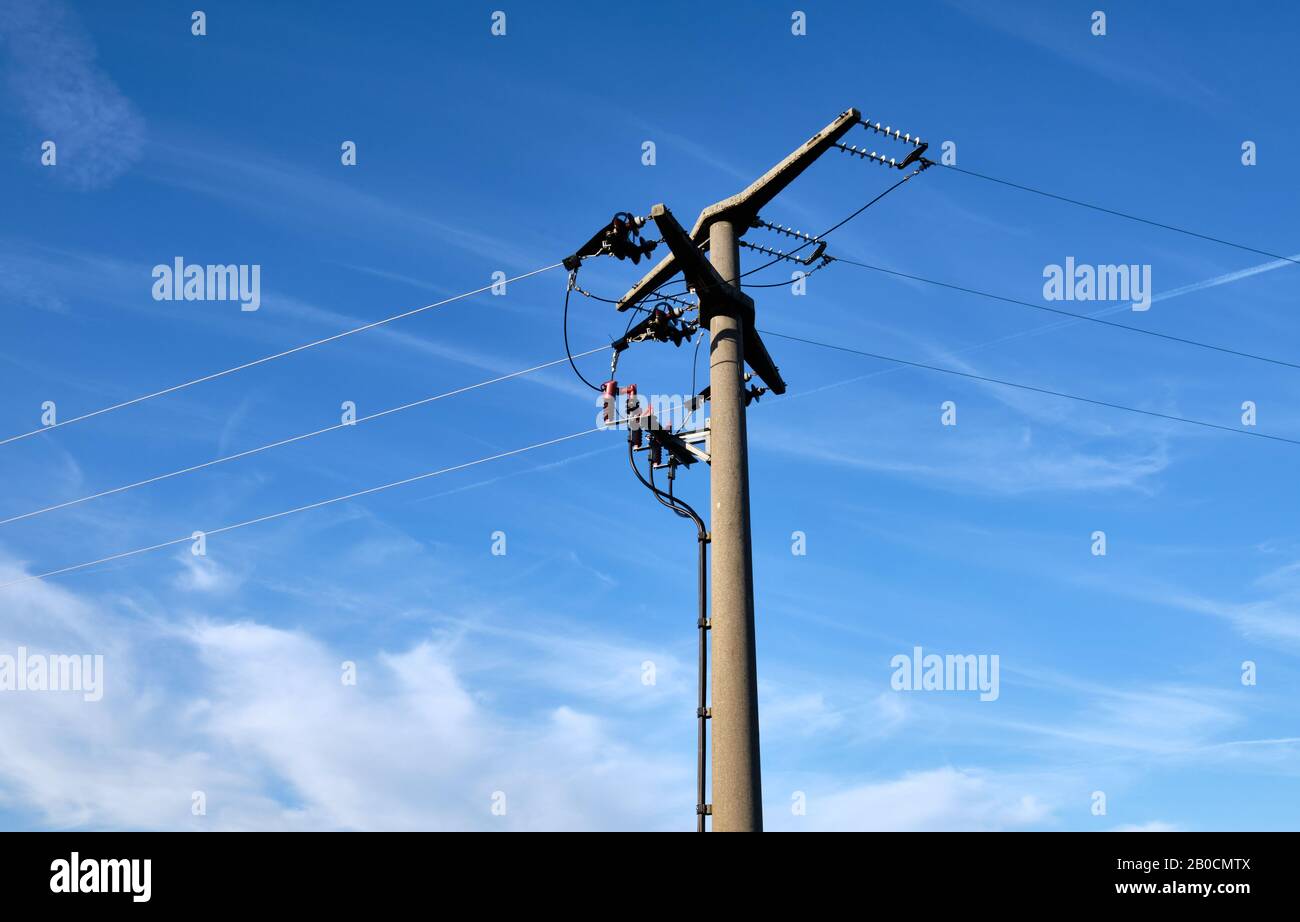 Nahaufnahme eines Hochspannungs-Pylons aus Beton von unten gegen blauen Himmel mit Kopierraum in Deutschland Stockfoto