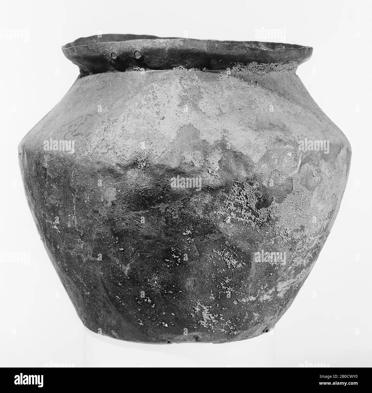 Kleiner bronzener Eimer mit leicht eingezogenem Boden. Breiter, wulstiger Bauch, dessen größte Breite über der Mitte liegt. Schmale, nach außen gerichtete Kante, deren oberer Teil vertikaler ist. Befestigung und Griff fehlen, aber die Nietlöcher zur Bestätigung sind noch vorhanden, 2 Paare, die sich gegenüberliegen. Bruijne patina, oben teilweise Flusssandbesetzung, Geschirr, Eimer, Metall, Bronze, Höhe: 17,1 cm, Roman 1-300, Niederlande, Gelderland, Nijmegen, Nijmegen Stockfoto