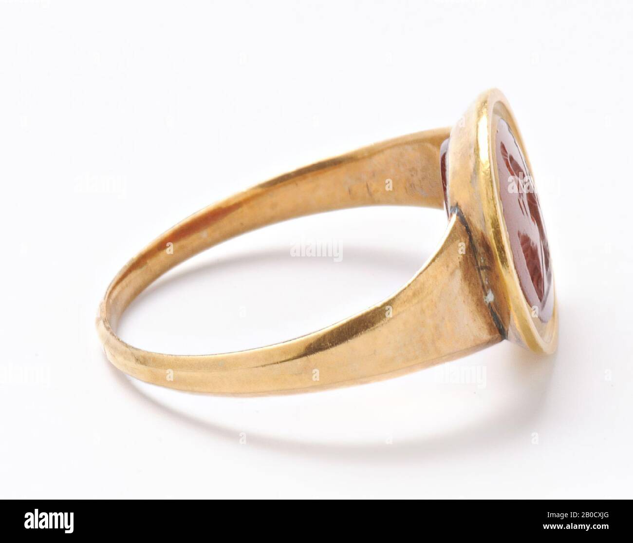 VZ: Die verschiedenen Teile einer Rüstung sind nebeneinander angeordnet, ein Paar Knemide, Parazonium und ein Centurion stehen diagonal hinter dem Kuirass mit Helm und Schild., Gem, intaglio, Ringstein, karnelisch, Farbe: Leuchtend rot, Form: Oval, Bearbeitet: Vorne konvex, in modernem Goldring, Methode: Flache Ausführung mit abgerundetem Bohrer, mit kurzen dicken abgerundeten Bandrillen., 14 x 12 mm, D. 3,5 mm, AD 2. Jahrhundert. 100-200 AD Stockfoto