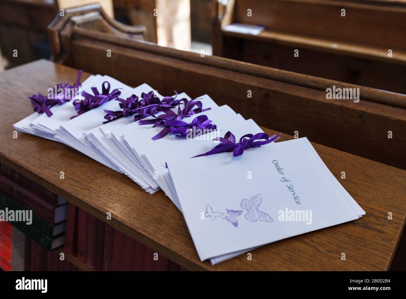 Auf der Rückseite von befinden sich Broschüren zur Bestellung von Services Eine Kirchenbäue für die Gäste zu sammeln, wenn sie betreten Die Kirche für eine Hochzeitszeremonie Stockfoto