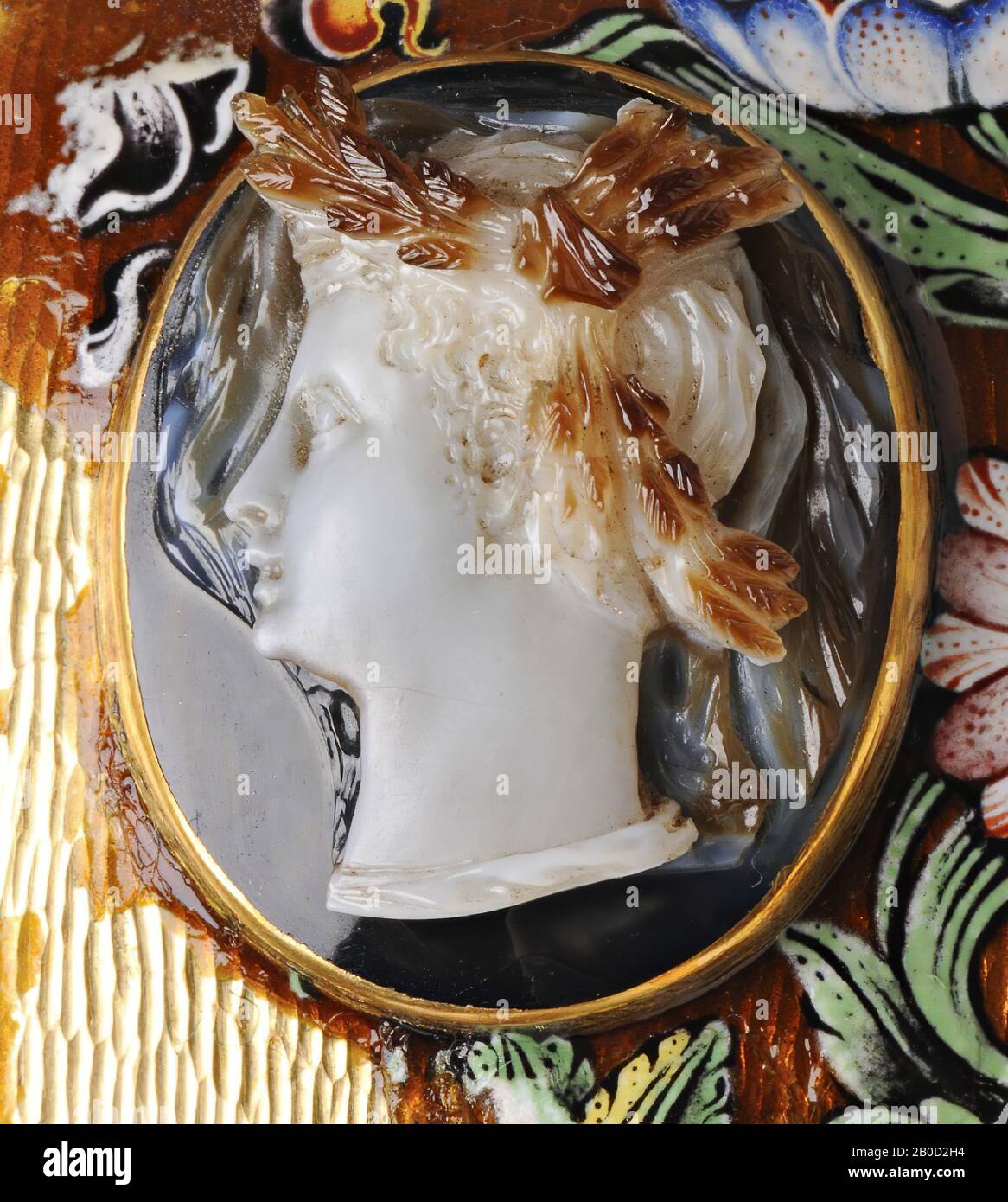 VZ: Die Person hat kurze Haare und eine Robe, die gerade am Anfang des Halses zu sehen ist, im Haar eine markante Pflanzendekoration mit drei Punkten, zwei der Punkte scheinen aus mehreren Maisohren und der letzte aus mehreren Mohnköpfen (?) zu bestehen. Cameo, Chalcedon (?), Farbe: Schwarz-braun Stockfoto