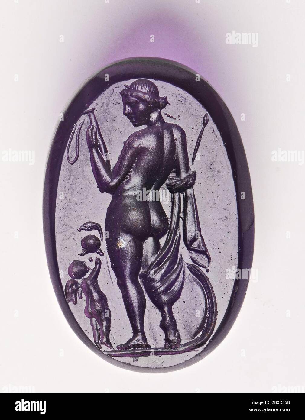 VZ: Die Gottheit ist in Dreiviertel-Rückansicht, mit dem Kopf nach links gedreht, hat sie ihren rechten Fuß spielerisch vom Boden gehoben, als wäre sie zu laufen und hat eine Robe um ihr rechtes Bein und rechten Arm gewickelt, In der rechten Hand hat sie eine Lanze und in der linken Hand einen nicht identifizierten Gegenstand (Schwertmantel mit Gürtel?), der kleine Cupid steht neben ihr und übergibt ihr einen Helm mit Kamm., GEM, intaglio, unbekannt, Farbe: Violett, Form: Oval, Verarbeitung: Kantenschnitt hinten im Vergleich zur Vorderseite, 17 x 27 x 5 mm Stockfoto