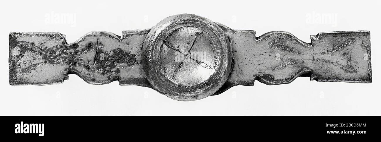 Band aus silveriertem Bronze. In der Mitte ist es mehr oder weniger oval und bis zu den Enden mit zwei Kerbpaaren auf beiden Seiten länglich, so dass das Band auf beiden Seiten des Mittelteils zunächst rechteckig, dann oval, dann rechteckig wird. In den extremen rechteckigen Teilen gibt es auch 1 Paar Kerben. Dekoration mit Stielen, die in Blättern enden. Im Stiftloch des Mittelteils wird mittels eines Stifts eine etwa Gleich große profilierte Scheibe befestigt. Ein bronzener Streifen (mit abgerundeten Enden) verläuft längs über den Rücken des Bandes und wird an beiden Enden von einer Stange und im gehalten Stockfoto