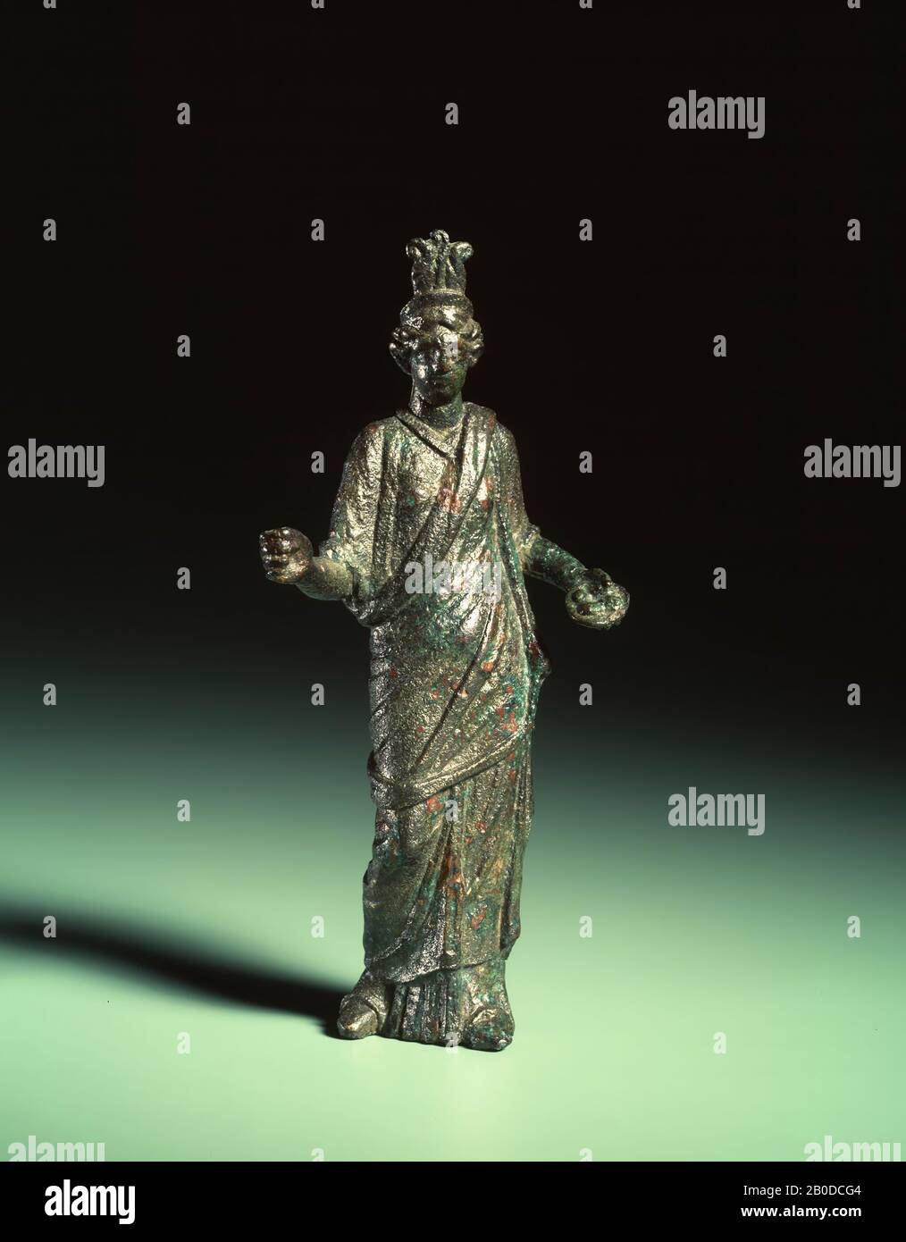 Bronzestatue von Isis, Hohlguss. Auf dem diadem ist sie mit 3 aufrechten Straußenfedern am Kopf erkennbar. In der rechten Hand hielt die Göttin vermutlich ein Sistrum. In der linken Hand hält sie eine Angebotsschüssel, auf der sich vier Gegenstände (Früchte?) befinden. Sie ist mit einer Stola bekleidet, auf der eine Palla steht. Die Palla wird über ihre linke Schulter geschlagen und löst ihre rechte Schulter. Die obere Kante der Palla wird aufgerollt, um einen Schärfen-Effekt zu erzeugen. Sie ist in der klassischen Kontrafosition: Figurin, Isis, Metall, Bronze, Höhe: 13,5 cm, roman 175-250 AD, Niederlande, Südholland, Katwijk, Valkenburg Stockfoto