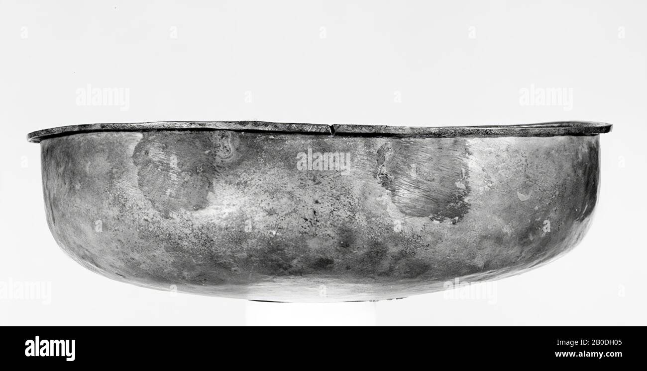 Bronze-Becken mit gewölbtem Boden, dass nach einem runden Winkel in der steilen, leicht biegenden Wand oben. Schmale, horizontal vorspringende Kante, die leicht unterschnitten ist. Zwei Paar gegenüberliegende Lötstellen, an denen die Griffe gelötet waren. Kaum patiniert. Antikreparatur mit einem Teller, in dem Bronze verzinnt ist, Geschirr, Becken, Metall, Bronze, Diam. 34 cm, h. 10,3 cm, Roman 1-300, Niederlande, Gelderland, Rijnwaarden, Pannerden, Bijlandt Stockfoto
