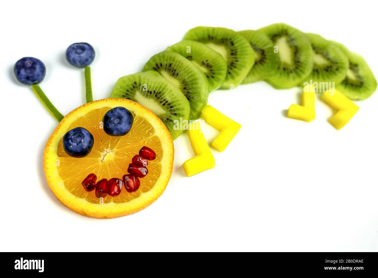 Lustiger Obstwurm auf weißem Teller gesundes Dessert für Kinder . Stockfoto