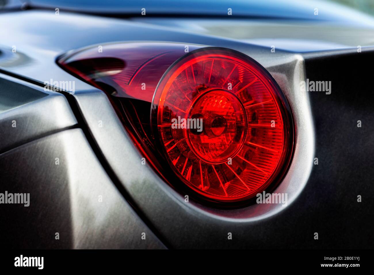 Detailansicht des hinteren Endes eines silberfarbenen Wagens mit Fokus auf die Schlussleuchte. Stockfoto
