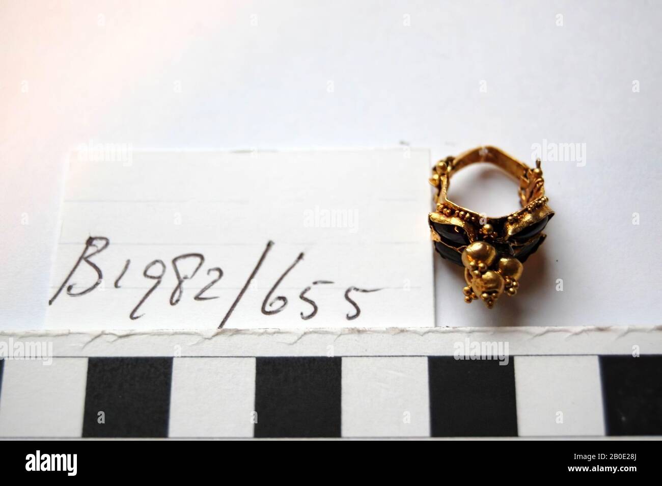 Ein goldener Ohrring mit Scharnierverschluss. Die Zierde ist mit einem Anhänger verziert und auf beiden Seiten zwei Paar Edelsteine mit Edelsteinen, Schmuck, Metall, Gold, Stein, Schmuckstein, D 2,5 cm, Achemenidenzeit 550-331 v. Chr., Iran Stockfoto