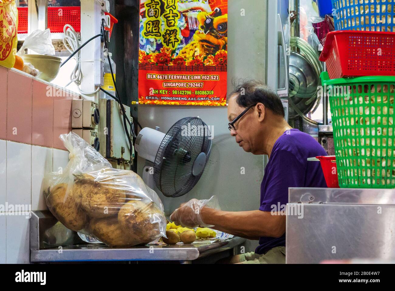 Mann, der in einem Küchen-Back-Shop arbeitet, der Gemüse und Lebensmittel zubereitet, die im Restaurant Chinatown, Singapur, Asien serviert werden sollen, Stockfoto