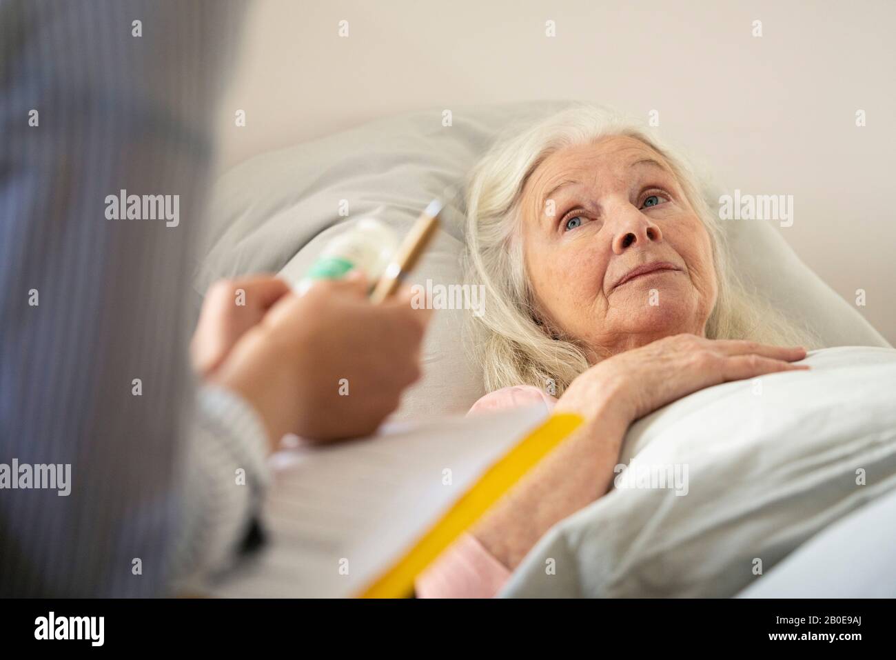 Ältere Frau, die zu Hause Pfarrer schaut Stockfoto