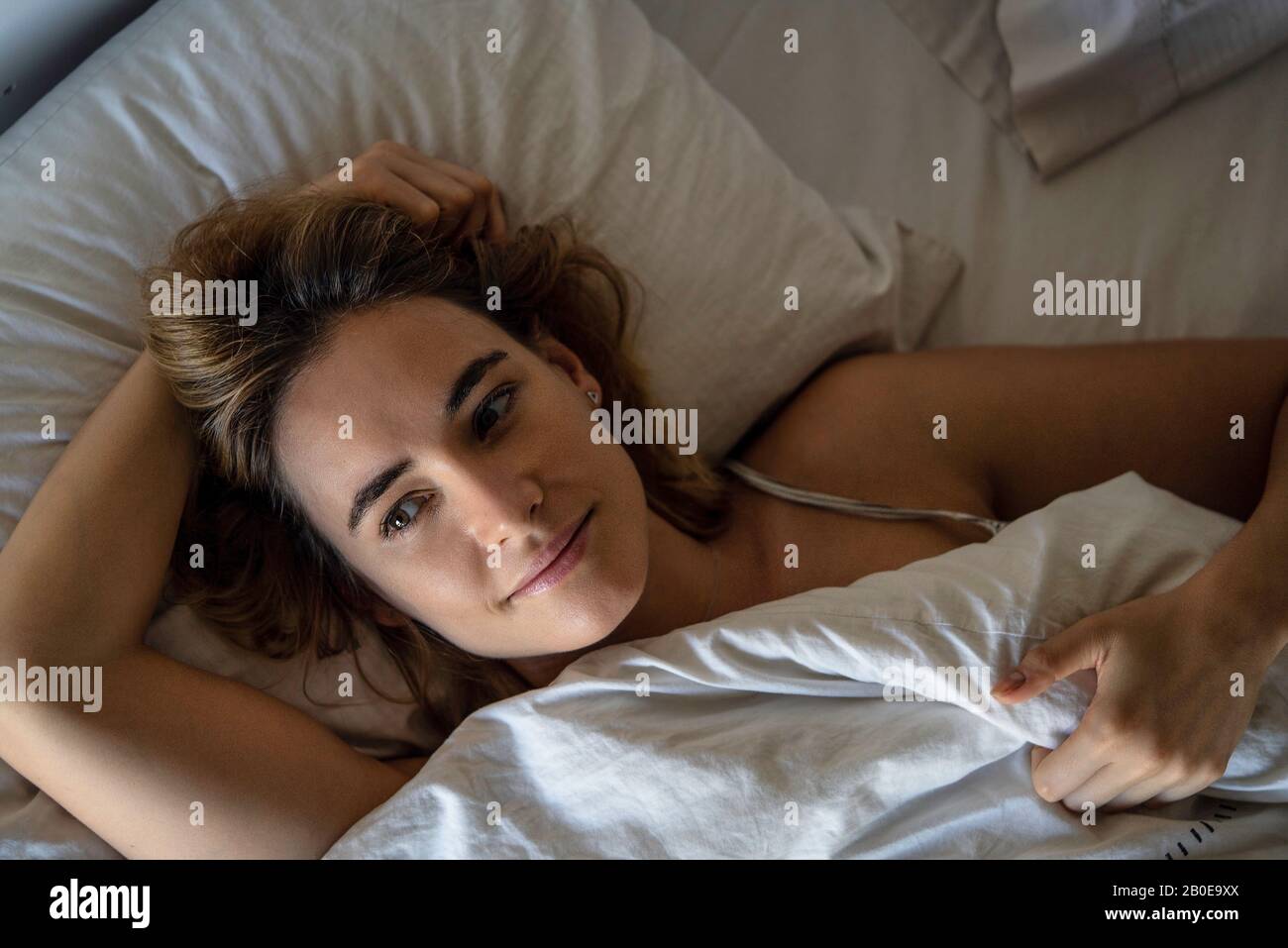 Junge Frau auf Bett liegend Stockfoto
