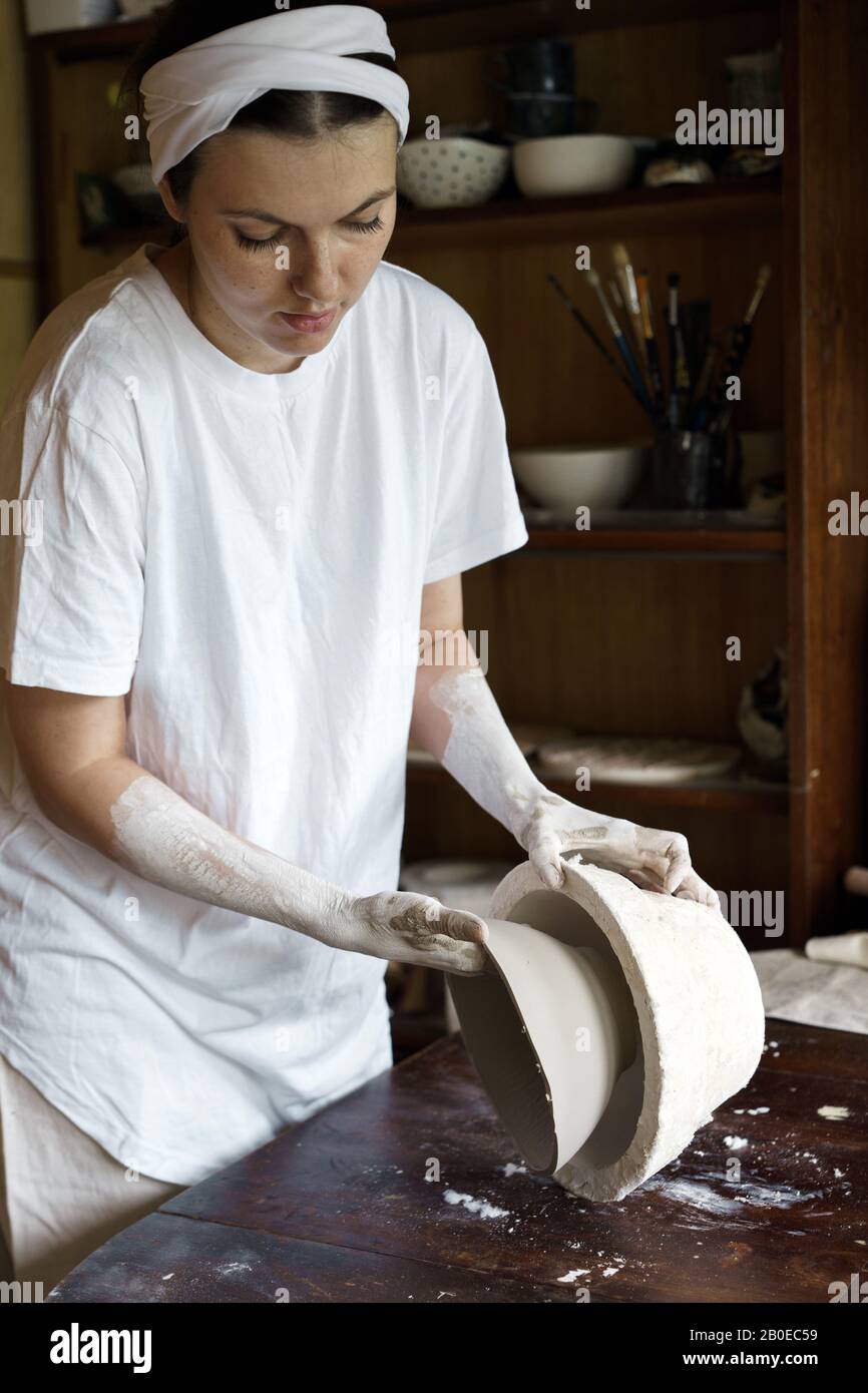 Weibliche Hände halten eine Schüssel für das Gießen von Ton-Produkte. Stockfoto