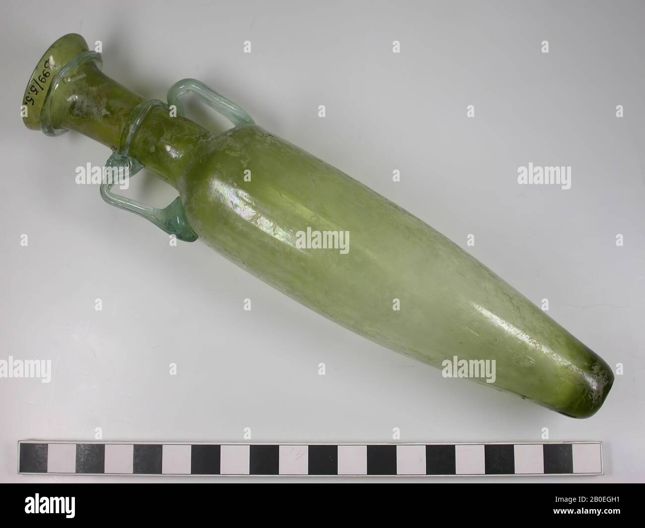 Spätrömisch spitzes, gelbgrünes Glas, geblasen, Amphora. Glasdraht-Dekoration rund um Mund, Hals und zwei Ohren aus blaugrünem Glas. Der Bauch ist mit vagen Graten versehen. Eine besonders markante Parallele ist eine Amphora, die im Juli 1934 in einem Grab aus dem 4. Jahrhundert in Beit Fajjar (ca. 25 km tz Jerusalem) gefunden wurde (heute im Archäologischen Museum Palästina ausgestellt). Siehe S.A.S. Husseini usw. Alle wesentlichen Merkmale unseres Stücks finden auch in der Kopie von Jerusalem statt. Auch die Abmessungen scheinen bei beiden Stücken (22 cm) praktisch gleich zu sein: Geschirr, Glas, H 22 cm, byzantinische Zeit 400-500 n. Chr. Stockfoto