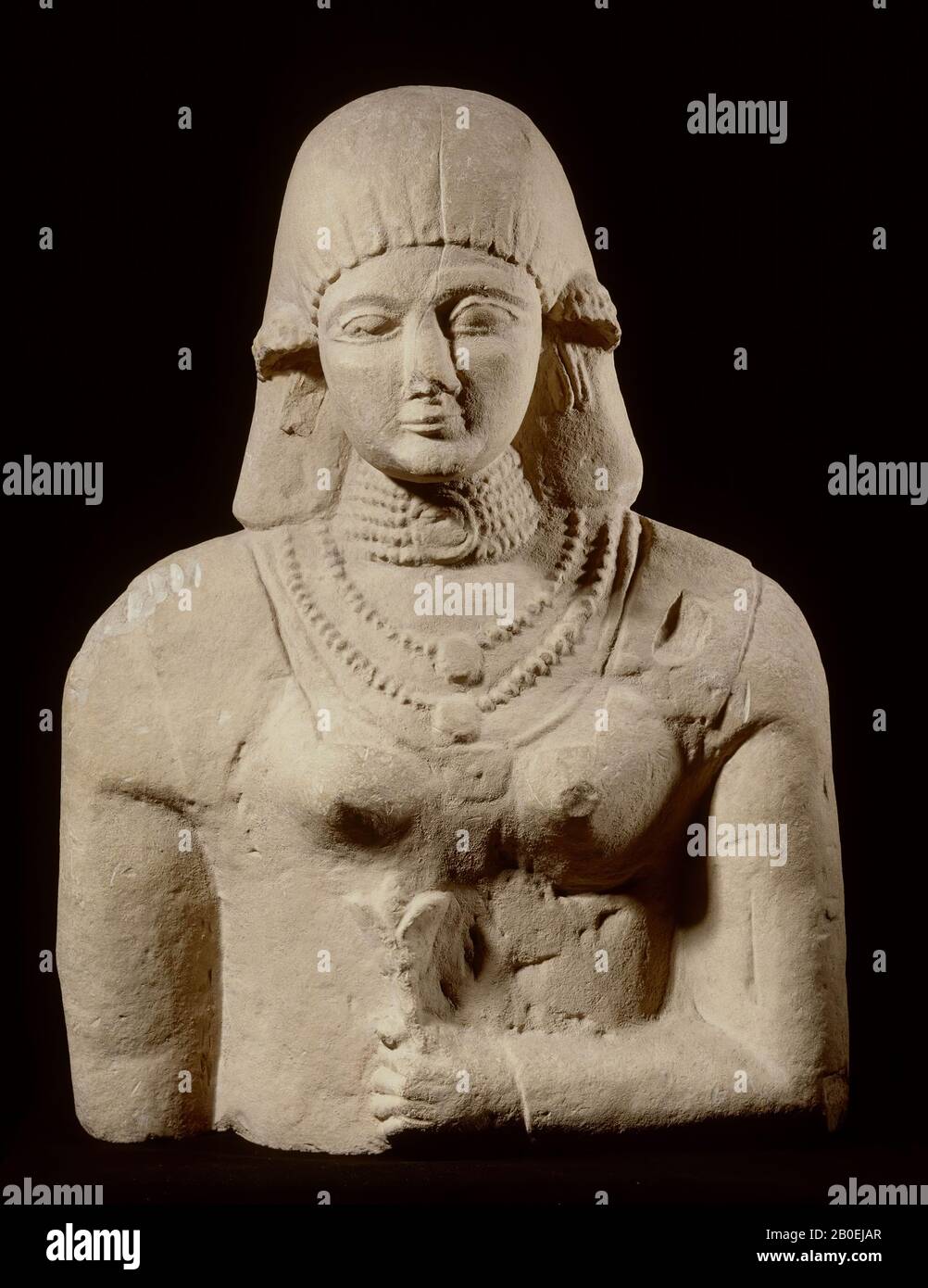 Die Frau ist mit einer eng anliegenden, langärmeligen Robe bekleidet, über der sie ein zweites ärmelloses Übergewand trägt. Vielleicht ist das Haarkleid eine Perücke. Sie trägt auch Schmuck in den Ohren. Die mandelförmigen Augen und das archaische Lächeln datieren das Bild im 6. Jahrhundert v. Chr., weibliche Statue, Kalksteine, 71,2 x 54 x 35 cm, archaische 555-545 v. Chr., Griechenland Stockfoto
