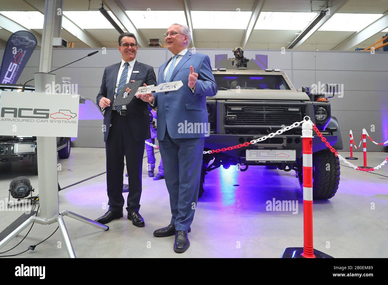 Friedberg, Deutschland. Februar 2020. Ulrich Belwe (l), Geschäftsführer der ACS-Gesellschaft, überreicht Joachim Herrmann (CSU), Bayerischer Innenminister, einen symbolischen Schlüssel für ein speziell ausgestattetes, gepanzertes Spezialfahrzeug der Polizei. Das Fahrzeug wurde in einer Zeremonie der bayerischen Polizei übergeben. Kredit: Karl-Josef Hildenbrand / dpa / Alamy Live News Stockfoto