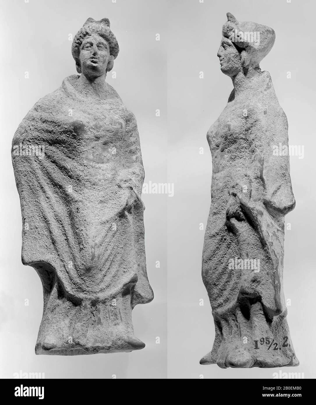 Ionische klassische Terrakotta-Figur der stehenden Frau mit rechter Hand an der Hüfte und in einem breiten Mantel. Strikkapsel. Weiß lackiert, Figurin, Steingut, Terrakotta, 24 cm, klassisch -350 Stockfoto