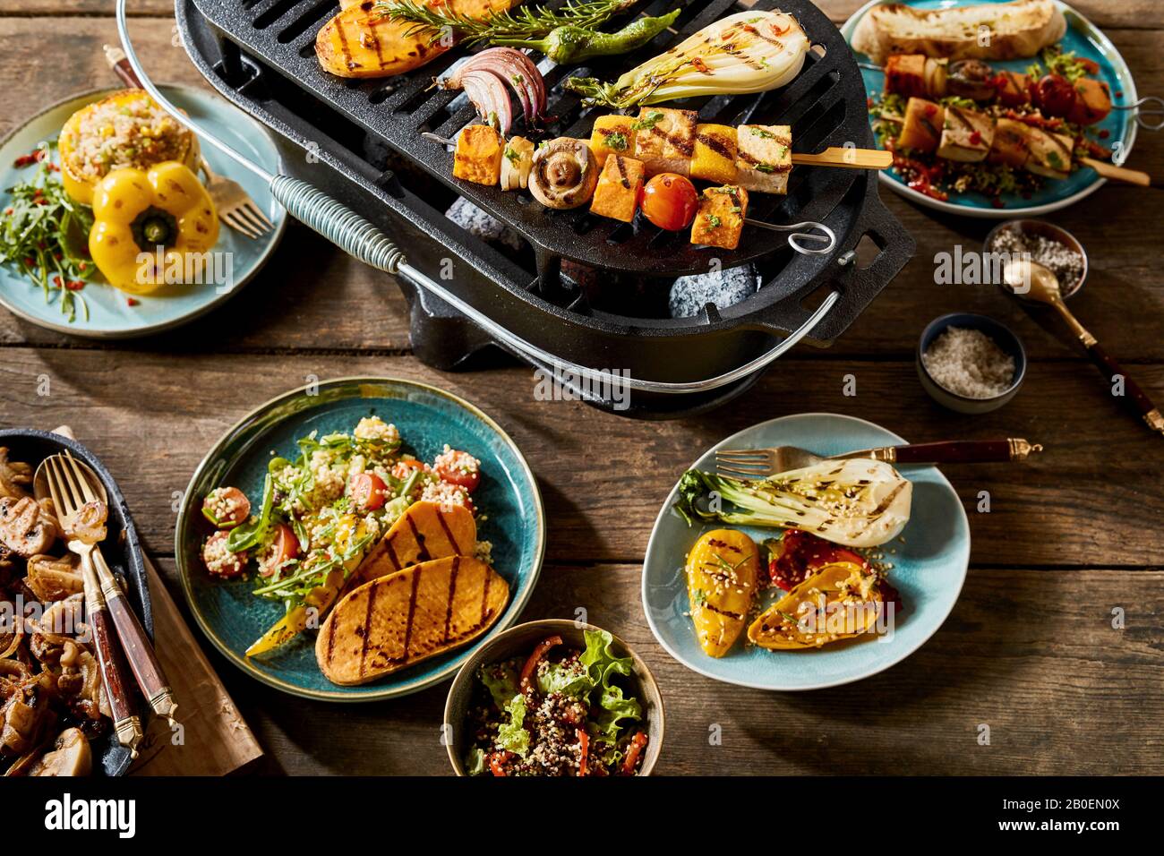 Vegetarisches und veganes BBQ Stillleben mit verschiedenen Bauernhof-frischen gegrillten Gemüse mit Tofu, Quinoa und Couscous auf einem alten rustikalen Tisch im Freien Stockfoto