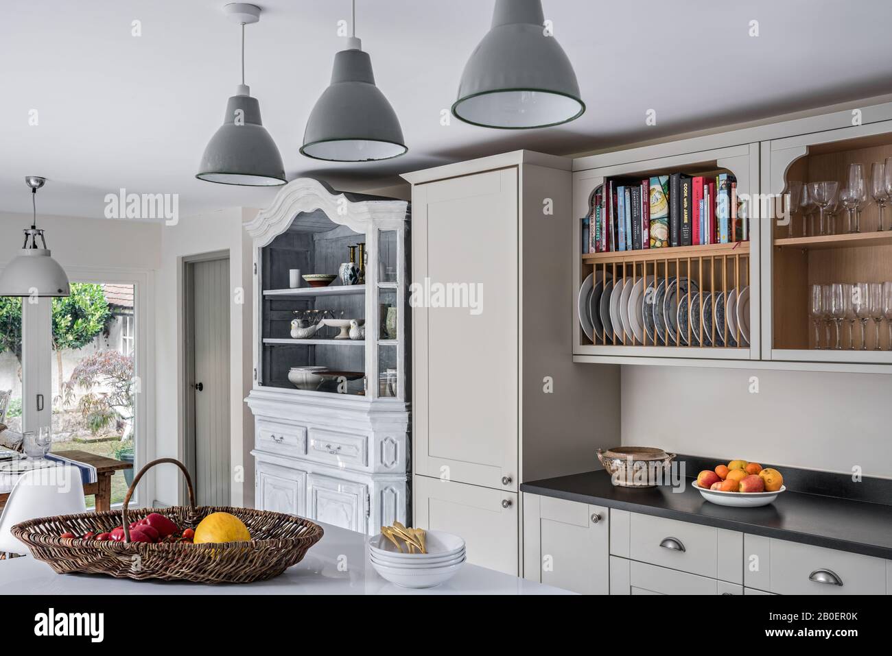 Belgische Oak Armoire aus den vierziger Jahren mit lackierten Lampenschirmen aus Amiens in Quäker-Küche mit Plattengestell über Granit Arbeitsplatte. Stockfoto