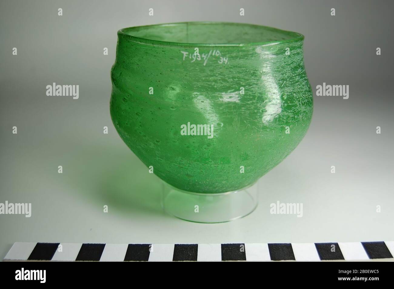 Cup, Cup aus apfelgrünem Glas, wahrscheinlich fränkisch. Der Kelch hat einen unregelmäßig kugelförmigen Körper, der in einer spitzen konvexen Unterseite und einem unbearbeiteten abgerundeten Lippenrand endet. Etwa auf halber Körpermitte wird eine horizontale Falte oder Rippe aufgetragen, Becher, Glas, frei geblasen, h. 8 cm, Durchm. 10 cm, koptische Zeit, Merowingerzeit 7. Bis 8. Jahrhundert, Ägypten Stockfoto