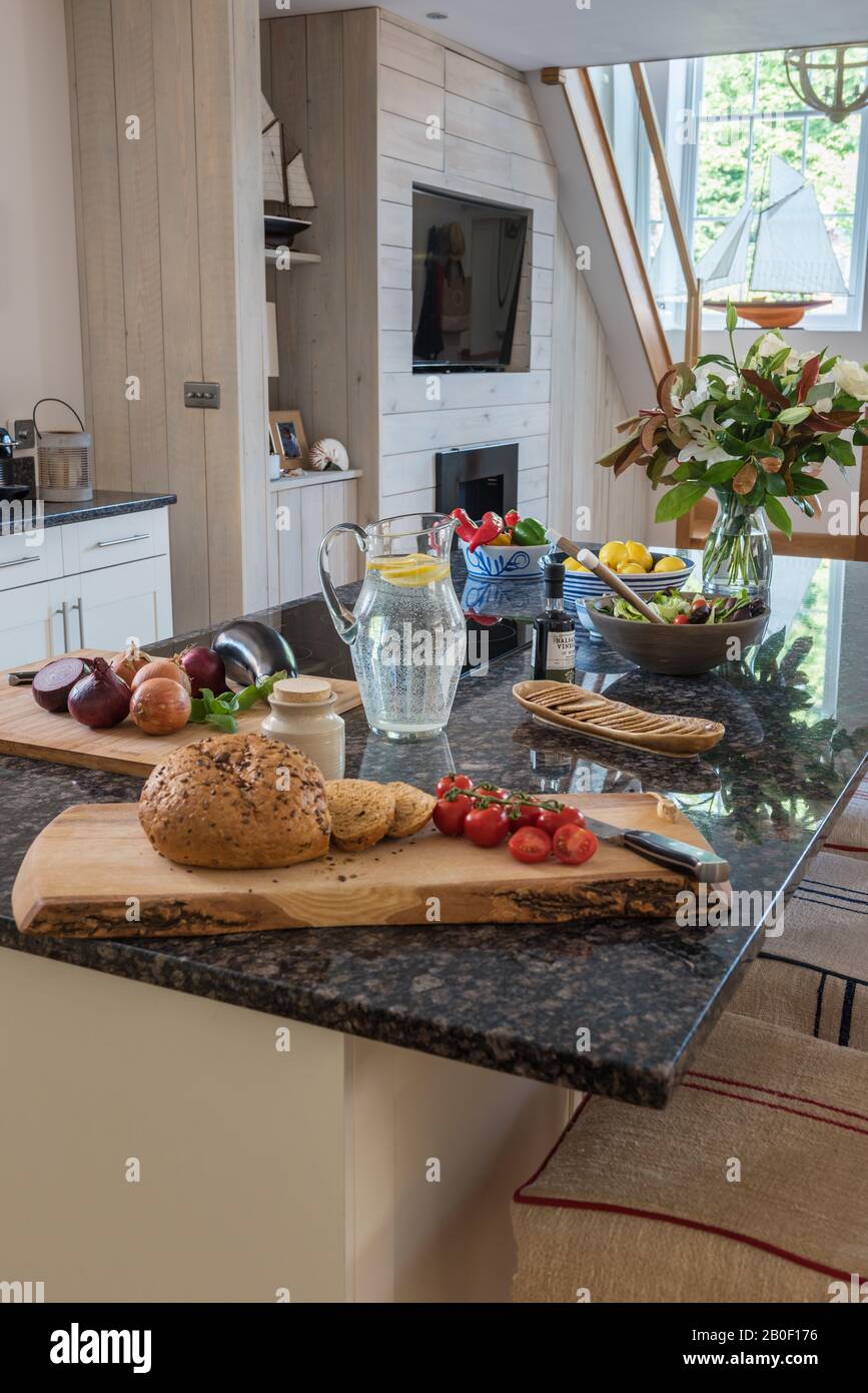 Frisches Brot und Gemüse auf der Kücheninsel aus Granit Stockfoto