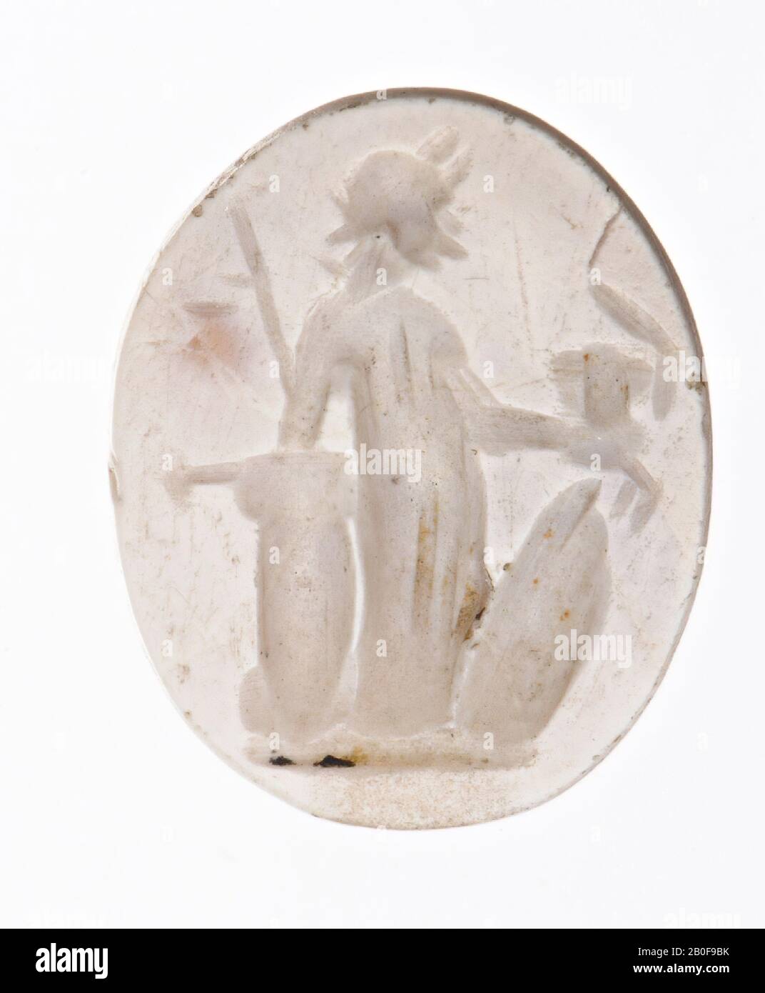 Die Göttin lehnt sich mit einer Lanze in der rechten Hand auf eine Säule zurück. In der ausgestreckten linken Hand ein Helm mit Kamm. Auf dem Boden vor ihr ein stehender Schild, Grundlinie, Schmuckstein, Intaglio, Ringstein, Stein, Achat, Farbe: Weiß (verbrannt, ursprünglich orange?), Undurchsichtig, Form: Oval, stehend, Bearbeitet: Maaskant-Kleibrink, M., Katalog der eingravierten Schmuckstücke im Königlichen Münzkabinett, 1978, S.60, Abb. 2, Typ F1, 12 x 9 mm. Stärke 3 mm, Niederlande Stockfoto