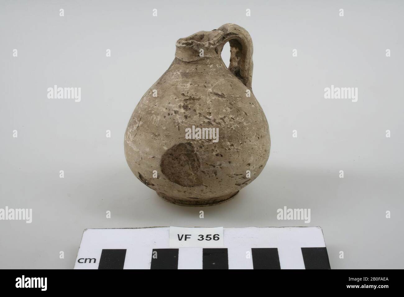 Sackförmige Glasdose mit hellgelber Rohrerdung mit Ohr (Kante beschädigt). Mit Oberflächenschäden, Kanne, Keramik, h: 8 cm, Durchm: 7,4 cm, roman, Niederlande, Utrechter, Bunnik, Kampf Stockfoto