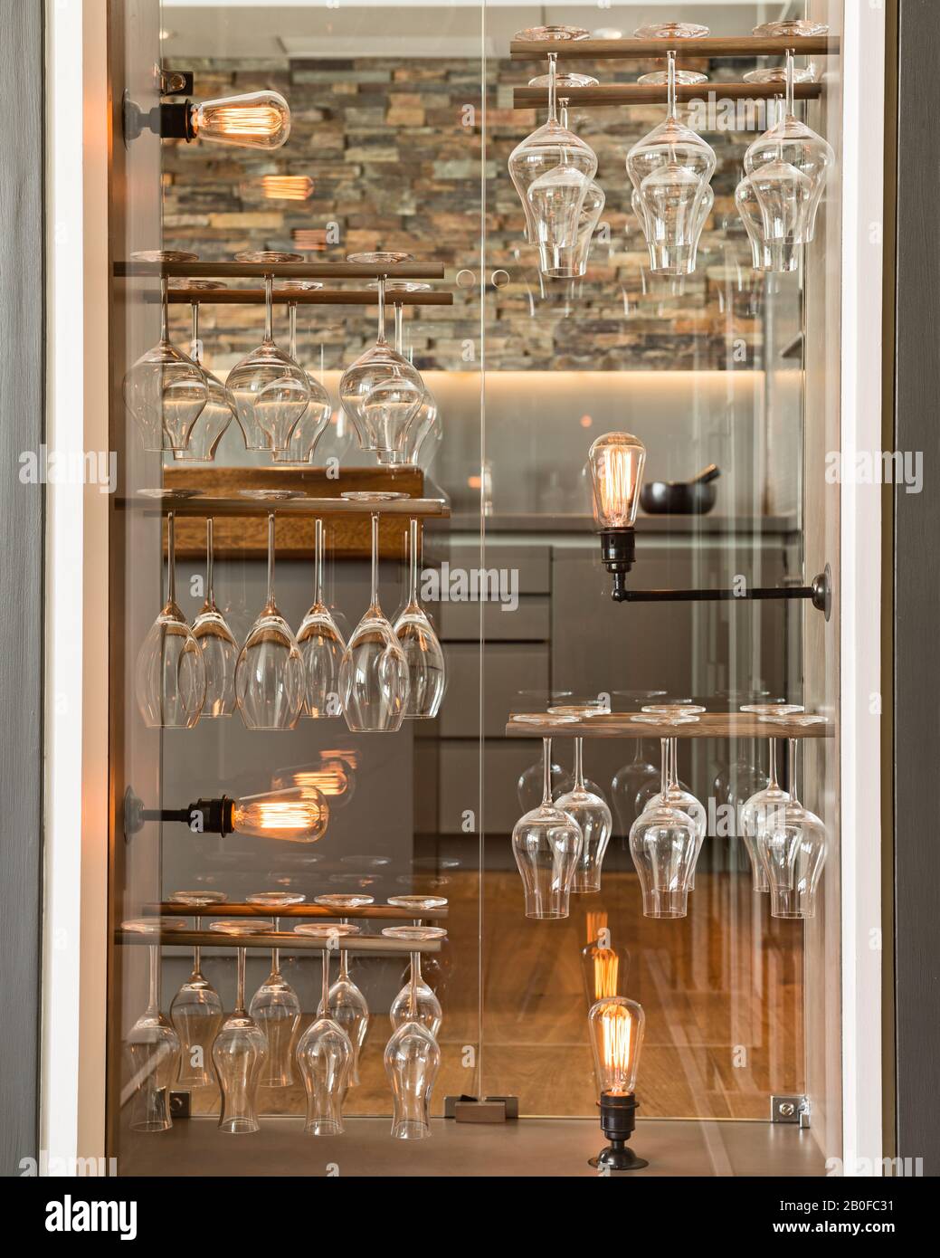 Redel-Wineglass-Lagerung mit Glühbirnen im umfunktionierten Türschrank. Stockfoto