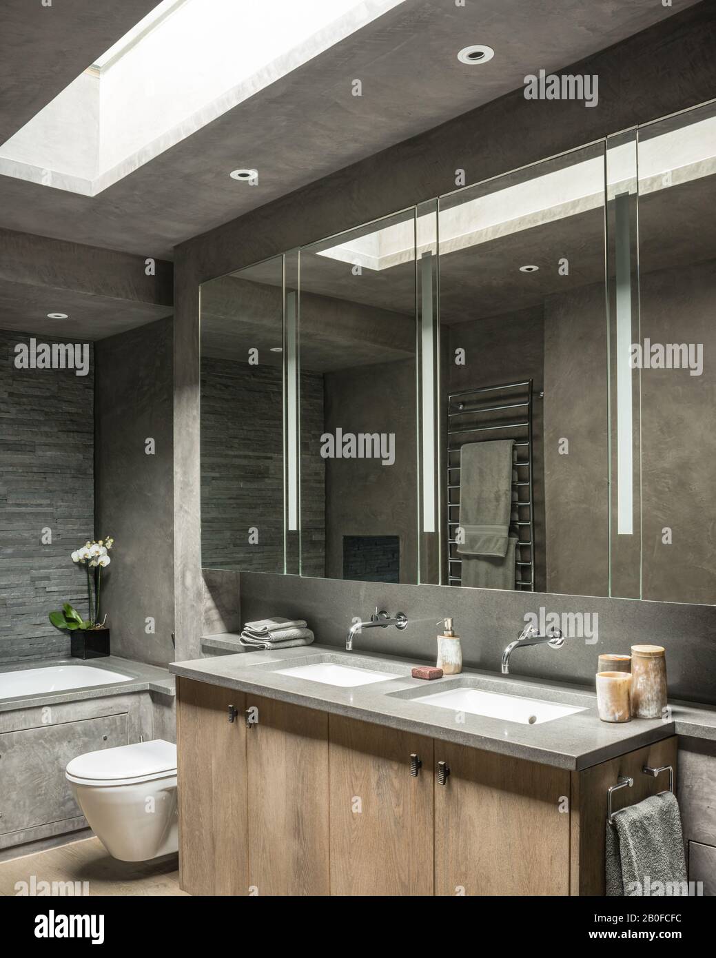 Große Spiegelschränke mit Doppelwaschbecken unter dem Oberlicht in der modernen West London Wohnung. Stockfoto