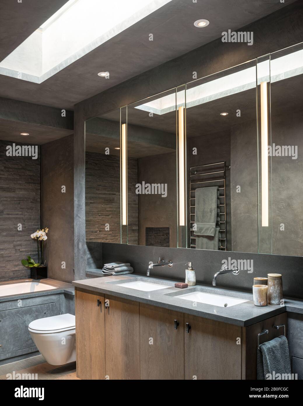 Große Spiegelschränke mit Doppelwaschbecken unter dem Oberlicht in der modernen West London Wohnung. Stockfoto