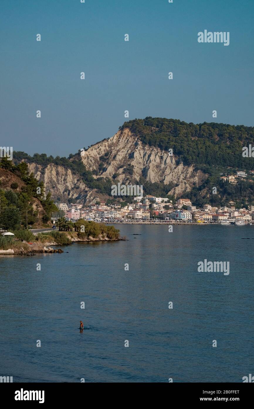 Ein Blick auf den Hafen von Zakynthos, der die Gebäude und den Hafen zeigt, die von den dominierenden Kalkfelsen übersehen werden. Stockfoto