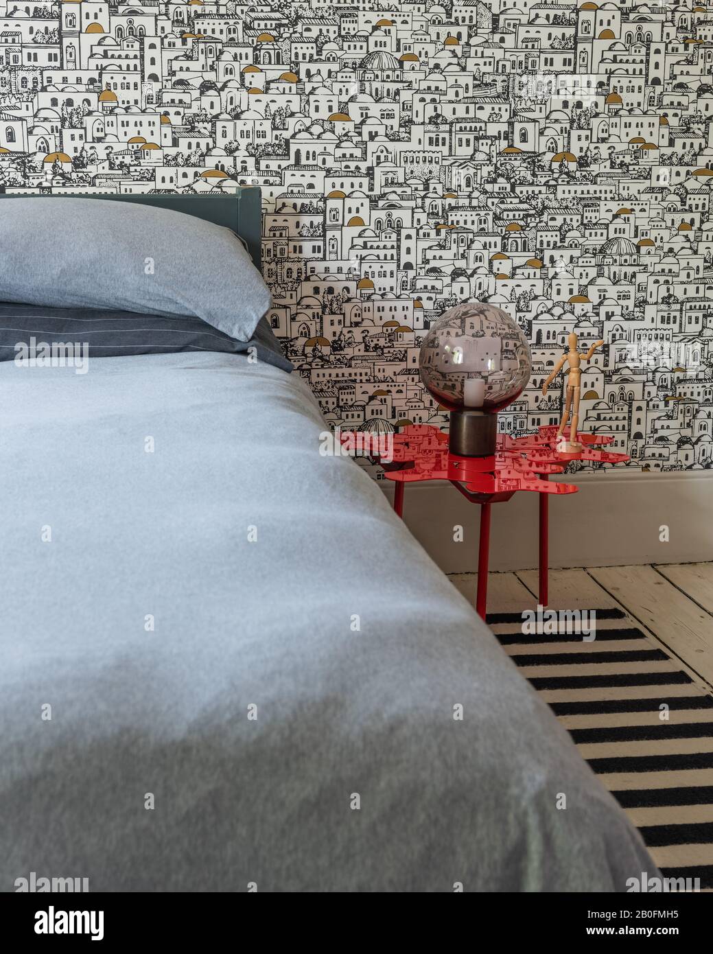 Grafische Schwarzweiß-Tapete und gestreifter Teppich mit Tisch von Moroso. Tapete ist Mediterraneo von Coles. Die Mond-Tischleuchte wird von CTO Lighting verwendet. Stockfoto