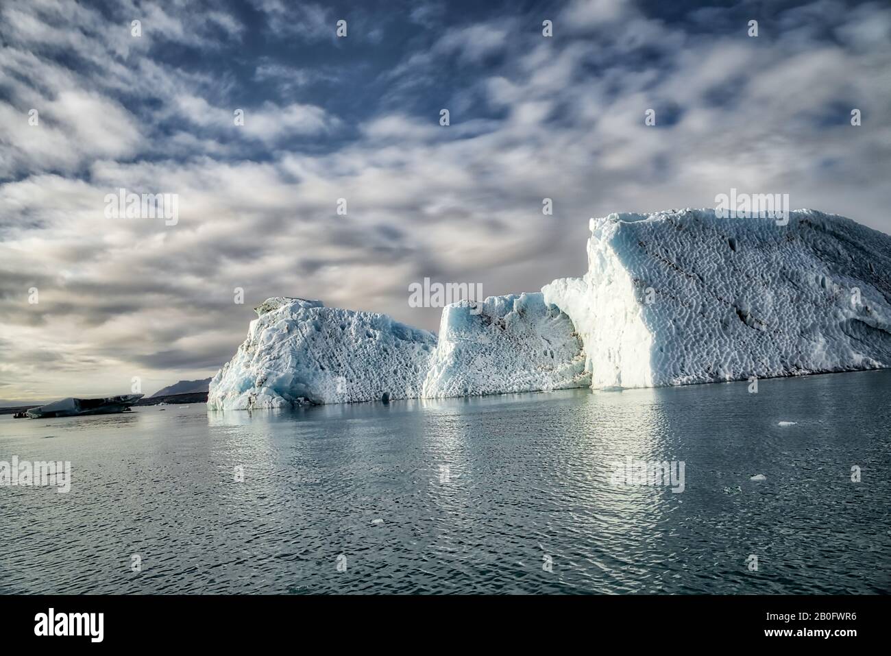 5 Isoliert Iceberg unterhalb der dramatischen Wolken - Jokulsarlon, Island Stockfoto