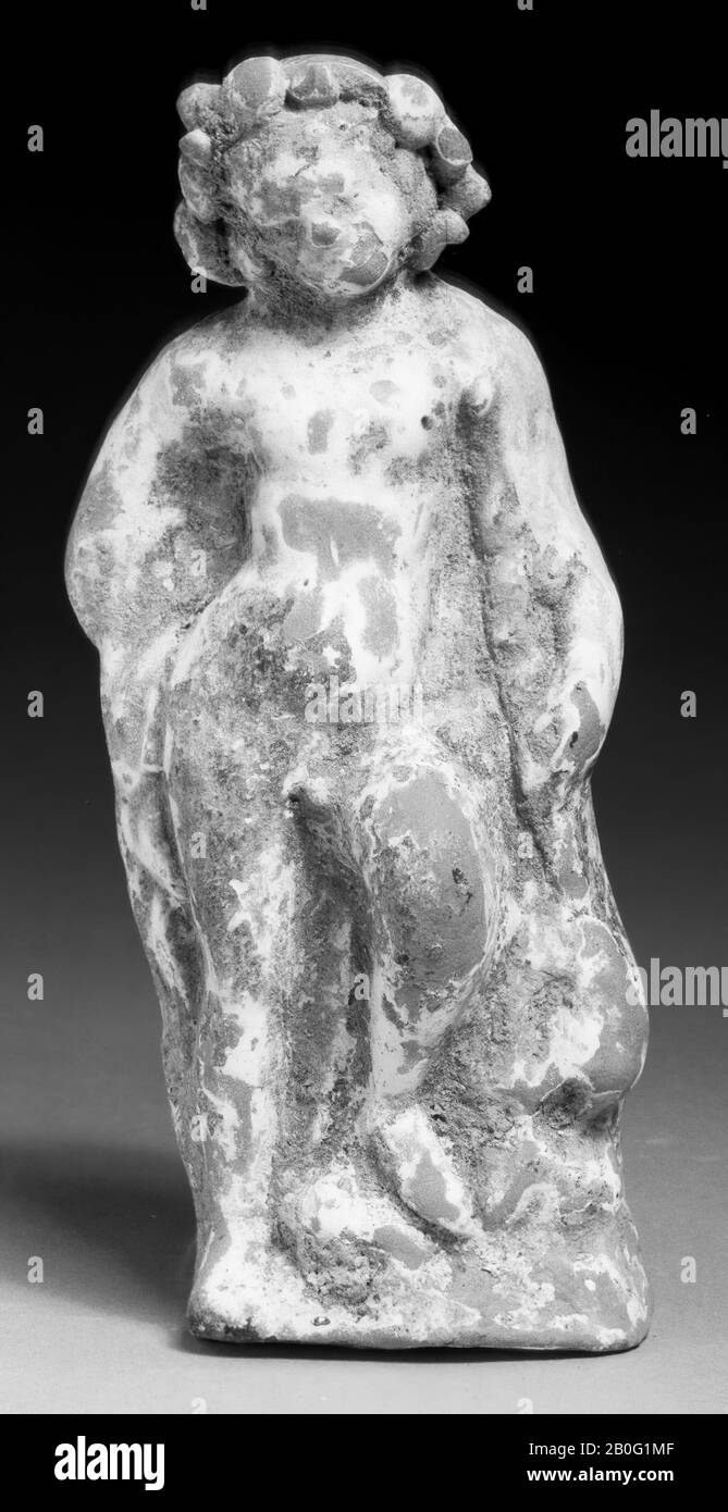 Kindliche Eros-Figur. Beiger Ton. Stützen auf dem rechten Bein, das linke (spielende) Bein etwas höher auf den Felsen platziert. Der rechte Arm, mit Kleidungsstücken, die um ihn herum hängen, ist auf dem Rücken schräg. Unter dem linken Achselhöhlen eine nach unten gerichtete Schräge. Der mit einem Kranz bekränzende Kopf biegt sich zur rechten Schulter. Weiße Engobe und Reste von rosa und (minimal) blauer Malerei. Öffnen Sie sich unten, auf den Frauenköpfen oder an den Griffen der Urne K 1980 Stockfoto